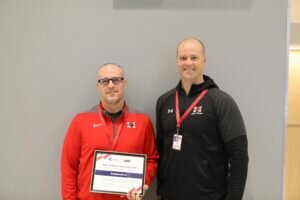 Donald Kura holding IHSA Swim Coach of the year award standing next to Maine South Athletic Director Matt Ryder
