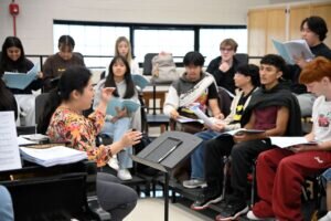 A music teacher guiding her students through a recital.