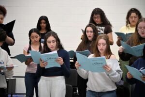 Choir Students Singing While Looking Down At Their Music