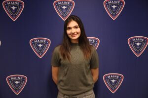 Portrait of Victoria Djurickovic against a blue background with District 207 logos